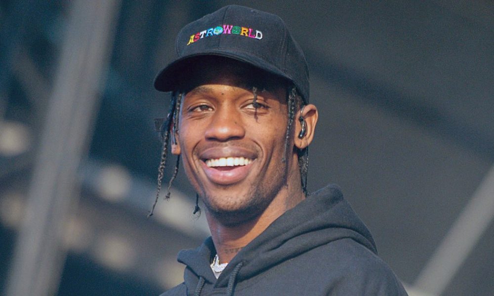 Travis Scott smiling during a concert | US Magazine