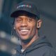 Travis Scott smiling during a concert | US Magazine